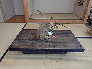 いけばな作品・立ち枯れ紫蘭、立ち枯れ霜柱、諸葛菜（ムラサキハナナ）、フキノトウ、綿、櫟の葉、枯れ芒