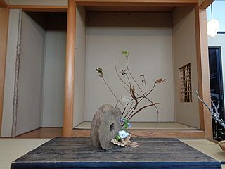 いけばな作品・立ち枯れ紫蘭、立ち枯れ霜柱、諸葛菜（ムラサキハナナ）、フキノトウ、綿、櫟の葉、枯れ芒