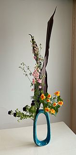 いけばな作品・ブラックリーフ、ピンク ラースクパー（千鳥草）、紫アスター、スプレーバラ(オレンジ）